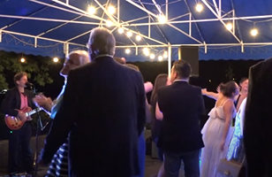 people dancing to live music at wedding reception
