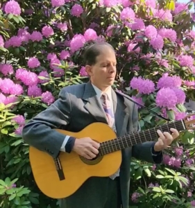Dennis playing guitar in front of magnolia tree at wedding ceremony