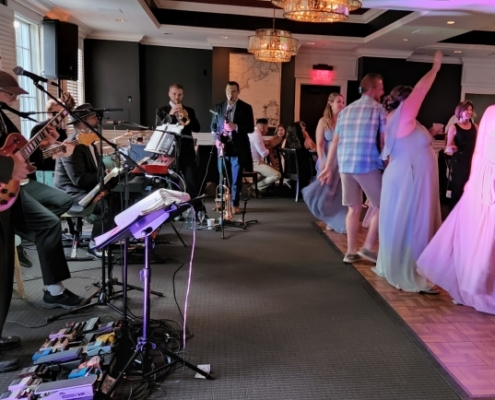 The Way Band with horns playing and people dancing at wedding