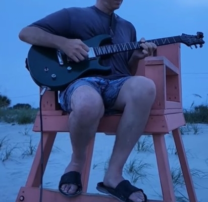 Dennis jamming in lifeguard chair at beach