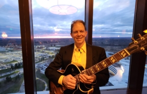 Dennis with jazz guitar at Turning Stone at sunset