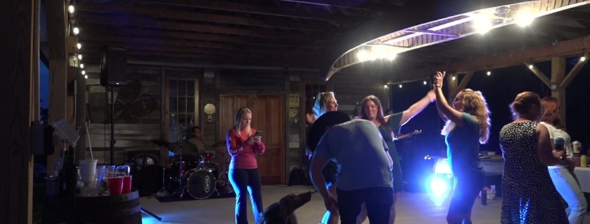 people dancing with dog at country wedding