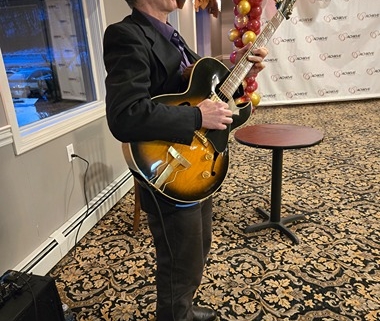 Dennis Winge playing guitar at 1244 Tavern