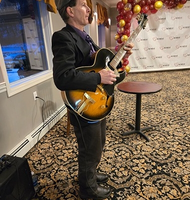 Dennis Winge playing guitar at 1244 Tavern