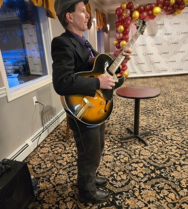 Dennis Winge playing guitar at 1244 Tavern