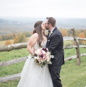 newly married couple kissing in a field