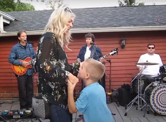 People dancing at a party with a live band for events playing in the background.