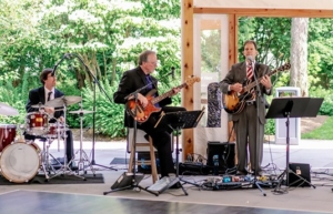 Wedding guitarist and band performing at outdoor reception