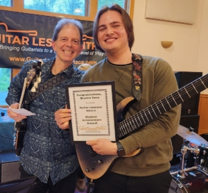 student receiving guitar lessons achievement award